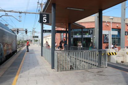 Varios usuarios esperan en el andén de la estación de Sant Vicenç de Calders tras la avería en la catenaria que afecta al servicio ferroviario.