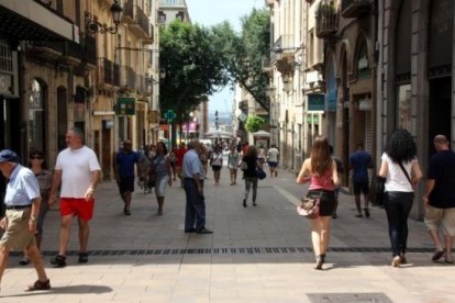 Pla general de gent passejant i comprant en un carrer de Tarragona.