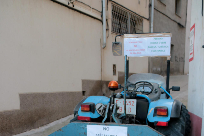 Un tractor amb pancartes contràries a l'abocador i carregat de fem al costat de la seu del consell comarcal de la Ribera d'Ebre.