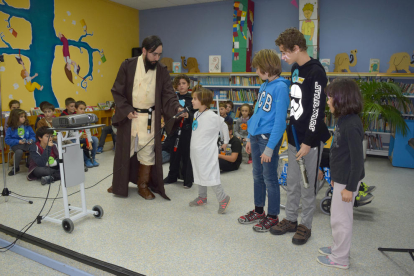 Uno de los grupos de los niños explicando de qué personaje van caracterizados a Emili Samper, disfrazado de Obi-Wan Kenobi.