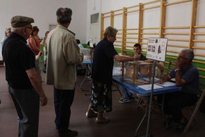 Tres electores hacen cola ante la mesa electoral en el colegio de IES Tarragona de Tarragona el 26 de junio de 2016
