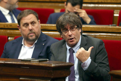 Carles Puigdemont y Oriol Junuers durante el debate parlamentario de este jueves.