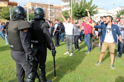 Dos agentes antiasonada de la Guardia Civil delante de varios ciudadanos con los brazos al aire después de entrar en el Pabellón Ferial de Móra la Nova y llevarse una urna.