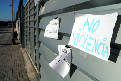 Primer pla de papers amb lemes contra la violència policial apegats a l'entrada de l'IES Joaquim Bau de Tortosa amb l'entrada buida d'alumnes a primera hora d'aquest dimarts, per l'Aturada de País