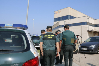 Agentes de la Guardia Civil, de espalda, delante de las puertas de las instalaciones de la imprenta de Constantí.