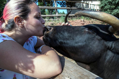 Anna Sánchez, coordinadora de prensa del Hogar Animal Sanctuary, dando un beso a la vaca Margarita.
