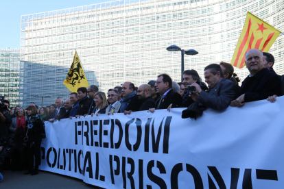 Els alcaldes desplaçats a Brussel·les llueixen una pancarta demanant l'alliberament dels presos polítics davant de la Comissió Europea.