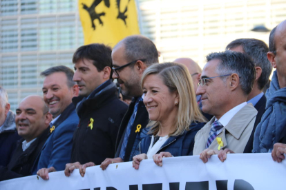 El presidente de la ACM, Miquel Buch, y la de la AMI, Neus Lloveras, sostienen la pancarta pidiendo desde Bruselas la liberación de presos políticos.