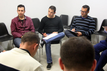 Imatge d'arxiu d'una teràpia de grup de Projecte Home a Tarragona, amb dos usuaris d'esquena i, al fons, el terapeuta del grup i dos usuaris més.