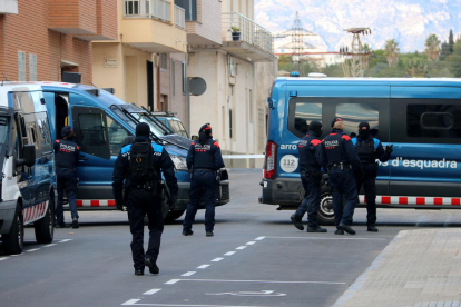 Plano conjunto de agentes de los Mossos y la policía local de Amposta durante el operativo policial contra el blanqueo de capitales en la calle Agustina de Aragón.