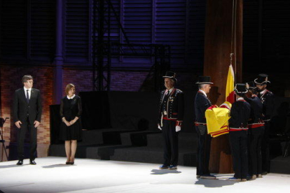 Puigdemont y Forcadell observan a los Mossos vestidos de gala apunte de izar la bandera al acto de la Diada celebrado en el Born, el 10 de septiembre de 2017.