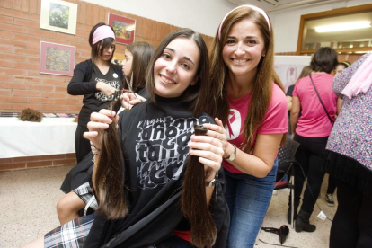 Una alumna sostenint la cua de cabell que s'ha tallat per donar-la a la fundació Mechones solidarios.