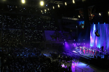 Centenares de personas hacen puntos de luz con su teléfono móvil durante la interpretación de 'Que tinguem sort', en el concierto 'Casa nostra, casa vostra', en el Palau Sant Jordi de Barcelona.