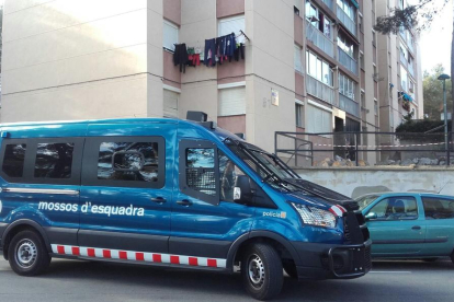 Un furgón de los Mossos D'Esquadra delante de algunos de los pisos donde se han realizado registros, en el barrio de Sant Salvador.