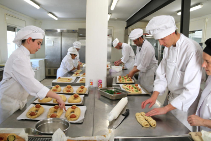 Plano general del Obrador de la Escuela de Hostelería de las Tierras del Ebro con los alumnos y profesores elaborando monas tradicionales de rosca y huevos duros.