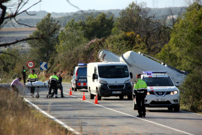 Imatge del camió cisterna accidentat mentre els forenses i els mossos retiren el cos de la víctima. Pla general