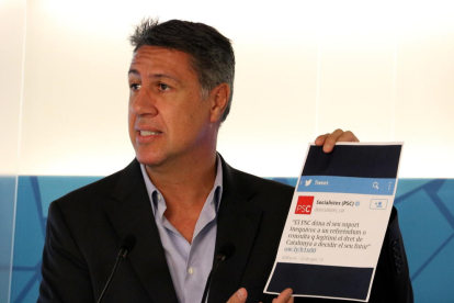 El president del PPC, Xavier García Albiol, mostrant un paper amb una piulada del PSC.