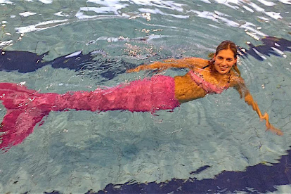La jove sirena a la piscina amb la cua de color rosa.