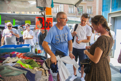 El comerciant, ahir al matí, a Corsini, amb dos turistes francesos que compraven roba.