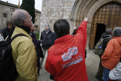 Plano medio de un guía donante explicaciones en un grupo de turistas de visita al patrimonio medieval de Montblanc.