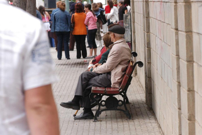 Imagen de archivo de personas mayores sentadas en un banco.