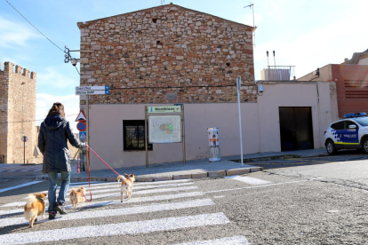 Pla general de l'exterior de la comissaria de la Policia Local de Montblanc i del magatzem on es guarden temporalment gossos abandonats, i d'una noia passejant tres gossos per la zona, en una imatge publicada el 26 de desembre del 2016