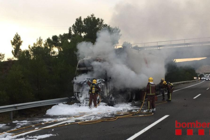 Los Bomberos apagando el fuego, que se ha originado en la cabina del camión.