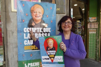 La Cèlia Rovira a fuera del establecimiento con el cartel de la Grossa de Cap d'Any.