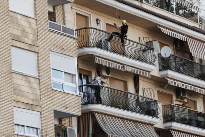El policía acercándose al balcón, donde había la mujer con sus dos hijos.