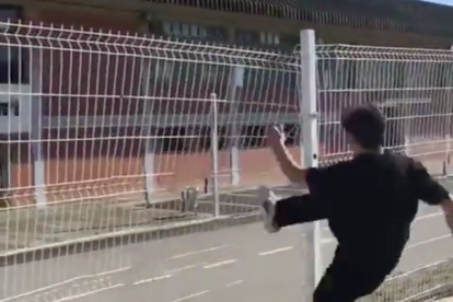 Imatge del vídeo en què uns joves destrossen la tanca del pavelló municipal.
