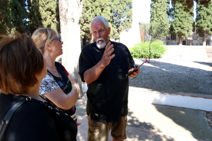 Plano medio Plano de las concejalas del Ayuntamiento del Perelló Carme Bladé y Maria Cinta Llaó, con Ivan York, con el espacio de la fosa|foso común al fondo.