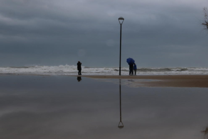Pla obert d'un grup de persones a la platja de Baix a Mar després del temporal a Torredembarra. Imatge del 22 de gener de 2017