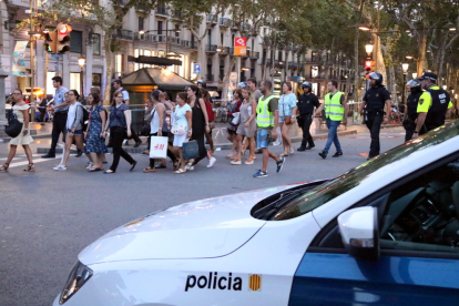 Agentes acompañando a ciudadanos para alejarse del centro de Barcelona el jueves por la tarde.
