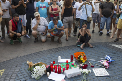 Flors i espelmes dipositades aquest divendres davant el mosaic de Miró a les Rambles de Barcelona.