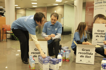 Voluntarios recogiendo la leche proporcionada por ciudadanos durante la campaña.