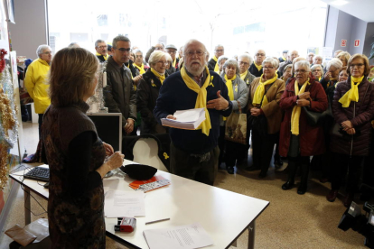 Pla mig del portaveu dels 'Avis i àvies per la llibertat' de Reus lliurant les cartes de queixa a l'oficina del Síndic de Greuges, desplaçada a la capital del Baix Camp, amb membres del col·lectiu al fons. Imatge del 18 de desembre del 2017