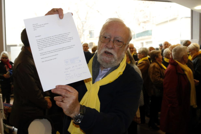 Plano medio de Josep Sierra, miembro de los 'Avis i àvies per la llibertat' de Reus, mostrando el justificante de entrega de más de 200 cartas de queja en la oficina del Síndic.