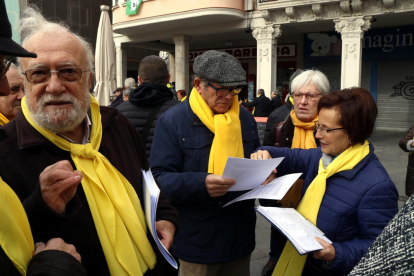 Josep Sierra (izquierda), miembro de los 'Avis i àvies per la llibertat', hablando en la plaza del Mercadal de Reus y Anna Barrabés (derecha), repartiendo el manifiesto que harán llegar al Síndic.