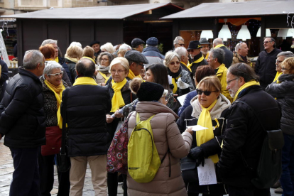 Plano cerrado de varias personas del colectivo 'Avis i àvies per la llibertat' de Reus, con bufandas amarillas, en la plaza del Mercadal el 13 de diciembre del 2017