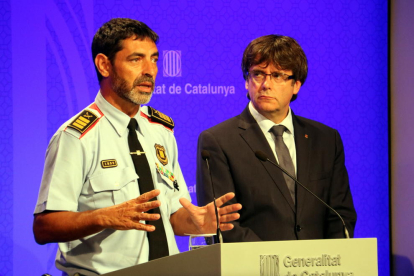 El presidente de la Generalitat, Carles Puigdemont, y el mayor de los Mossos D'Esquadra, Josep Lluís Trapero, durante la rueda de prensa del lunes por la tarde.