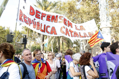 Personas concentradas en el paseo de Lluís Companys para seguir la comparecencia del presidente de la Generalitat.