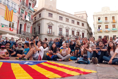 Una estelada estirada a terra davant dels ciutadans que segueixen des de la plaça del Mercadal de Reus la compareixença del president Carles Puigdemont.