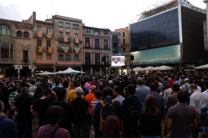 Los ciudadanos llenando la plaza del Mercadal de Reus siguiendo la comparecencia en una pantalla gigante.