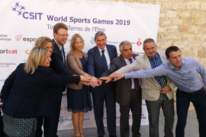 La consellera de Presidència, Neus Munté, i l'alcalde de Tortosa, Ferran Bel, entre altres, ajunten les mans en la presentació dels CSIT World Games. Imatge del 20 de maig de 2017