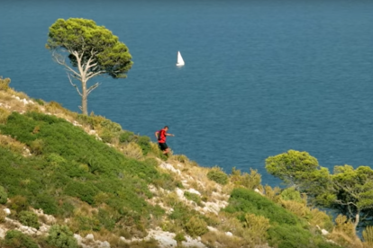 Una imatge extreta del vídeo, on el protagonista recorre una muntanya amb el mar de fons.