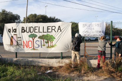 Uns veïns van penjar una pancarta en contra del Pla Parcial Urbanístic de la Budellera, abans de fer una marxa reivindicativa.