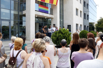Pla general de diverses persones concentrades davant l'Ajuntament de Cambrils per condemnar la mort d'una dona a mans de la seva exparella, amb l'alcaldessa, al fons, llegint un manifest. Imatge del 26 de juny del 2017