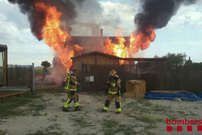 Imatge dels bombers treballant en l'extinció del foc que ha cremat una casa de fusta a Reus.