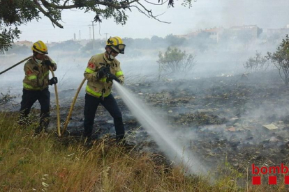 Els bombers, remullant la zona de l'incendi a La Canonja.