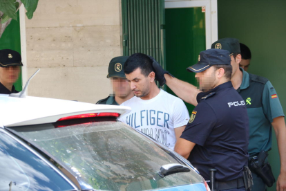 Agents de la Policia Nacional i la Guàrdia Civil s'enduen detingut el propietari d'un club de cànnabis d'Amposta i el fan pujar al cotxe policial. Imatge del 28 de juny de 2017 (horitzontal)